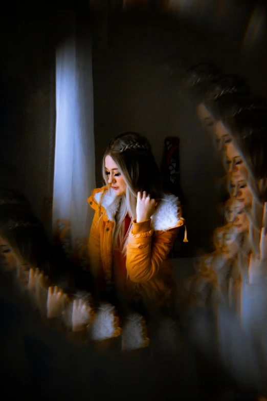 a woman sitting in front of a mirror talking on a cell phone, a picture, inspired by Elsa Bleda, pexels contest winner, orange fur, enveloped in ghosts, orton effect intricate, yellow