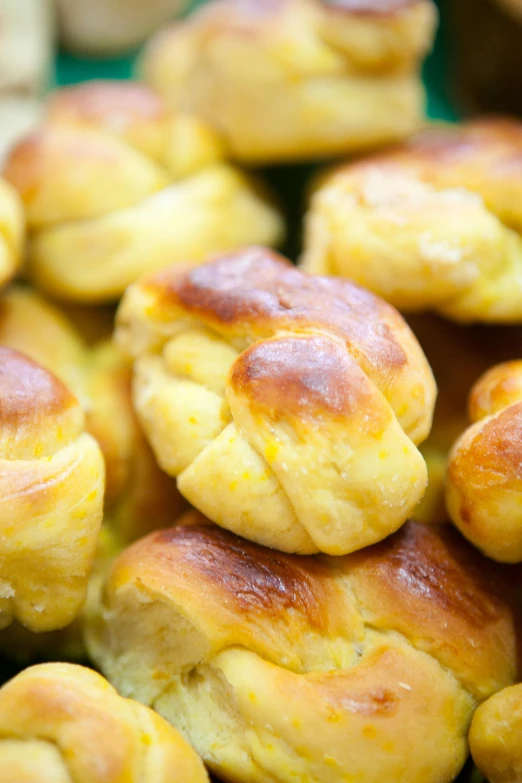 a pile of bread rolls sitting on top of a table, inspired by Géza Dósa, yellow flowers, close up details, brazilian, molten