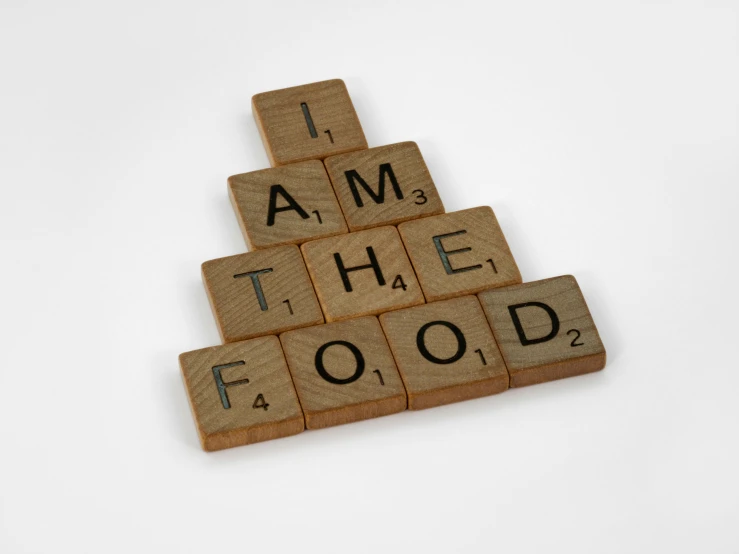 scrabbles spelling i am the food on a white background, a picture, by Emma Andijewska, dada, advertising photograph, avatar image, on wood, 3 4 5 3 1
