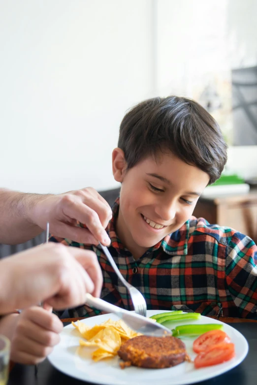 a little boy sitting at a table with a plate of food, bowl filled with food, holding a kitchen knife, high school, caring fatherly wide forehead