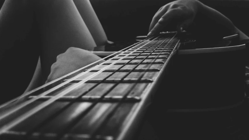 a black and white photo of a person playing a guitar, inspired by John McLaughlin, pexels, realism, closeup!!!!!!, foreshortened perspective, detailed »