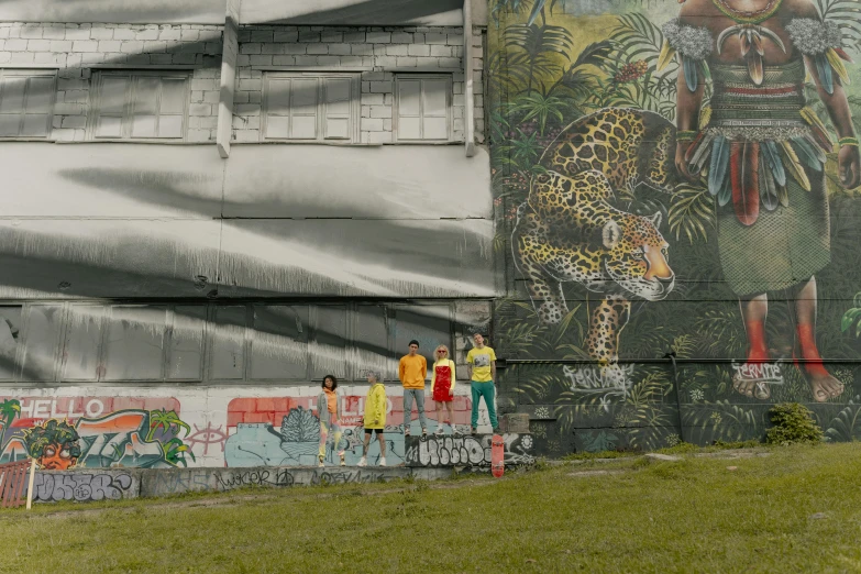 a group of people standing in front of a mural, city of the jungle, alexander abdulov, streetwear, large scale photo