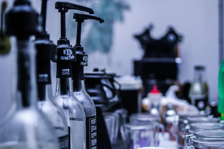 a bunch of bottles sitting on top of a table, profile image, aussie baristas, background image, fine black ink