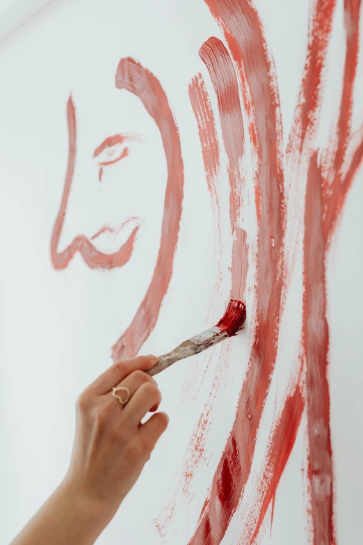 a woman is painting on a wall with a brush, inspired by David Alfaro Siqueiros, trending on pexels, process art, person made of tree, red face, with a white background, on a canva