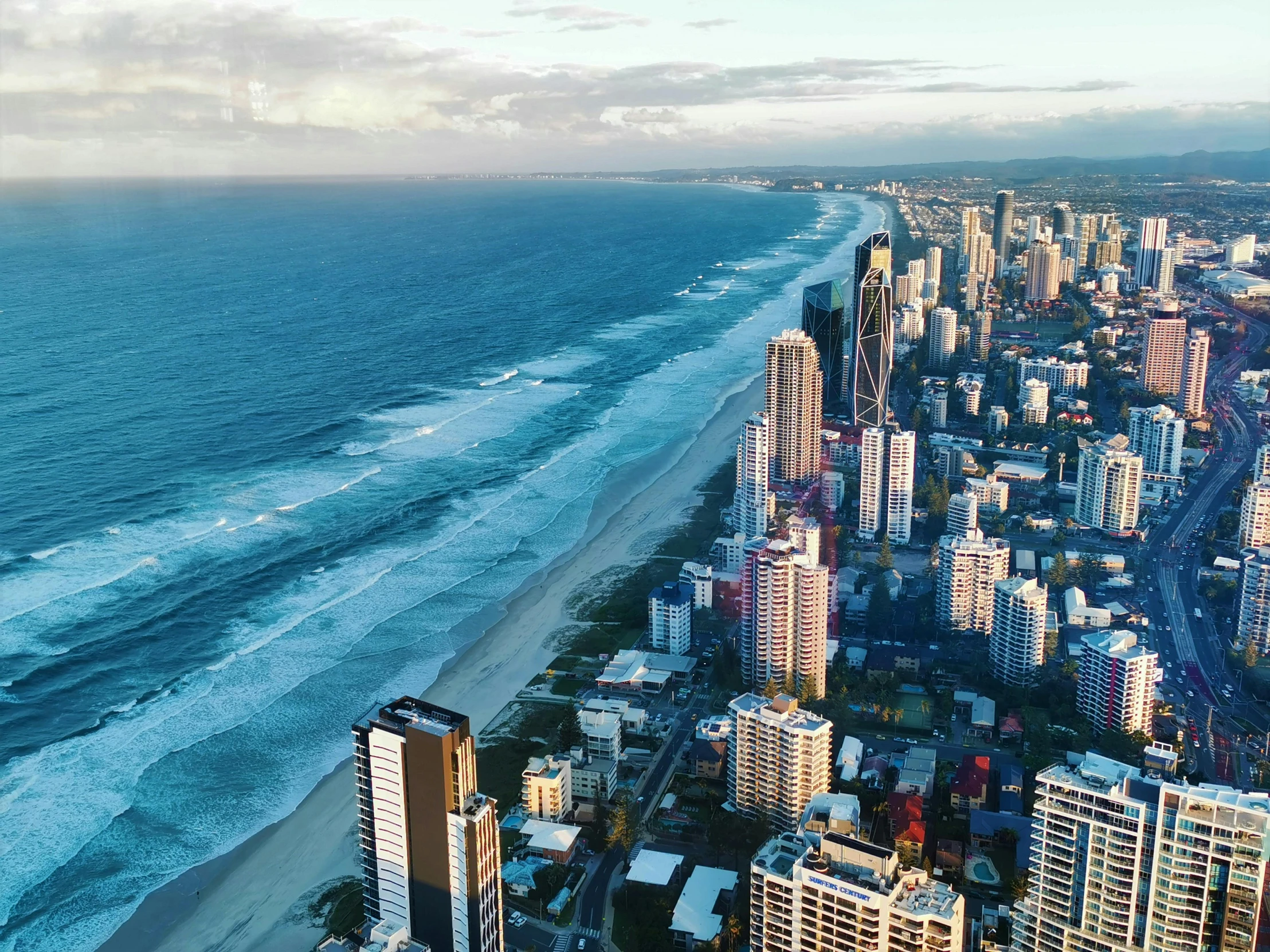 an aerial view of a city next to the ocean, by Lee Loughridge, pexels contest winner, gold coast australia, hd footage, rectangle, skies behind