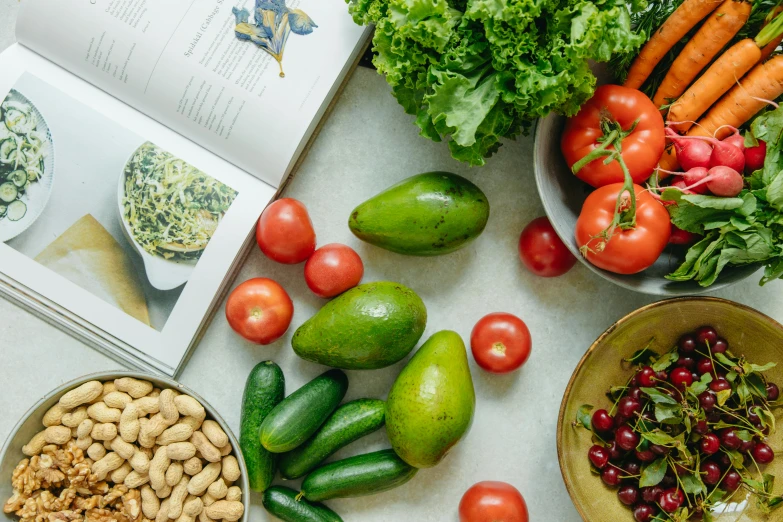 a book sitting on top of a table filled with fruits and vegetables, thumbnail, uncropped, salad, avocados