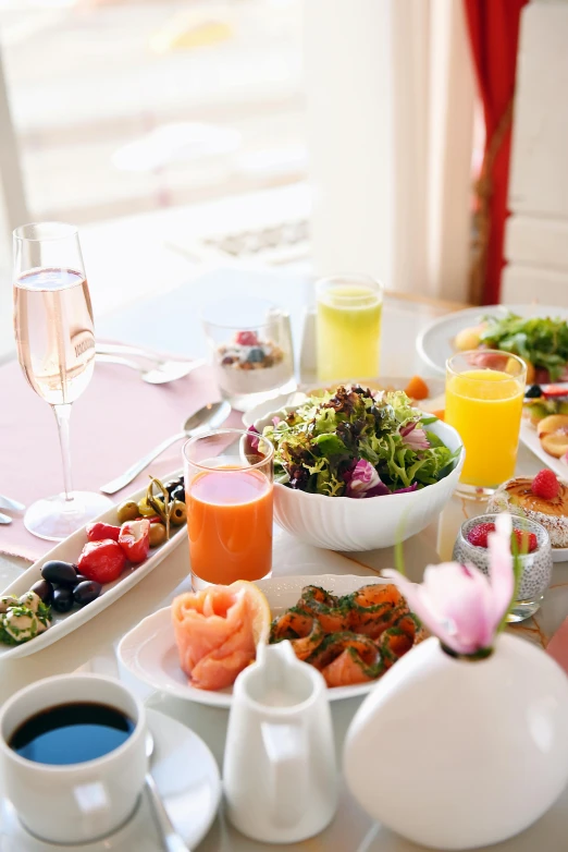 a table topped with plates of food and drinks, pink, salad, morning time, blushing