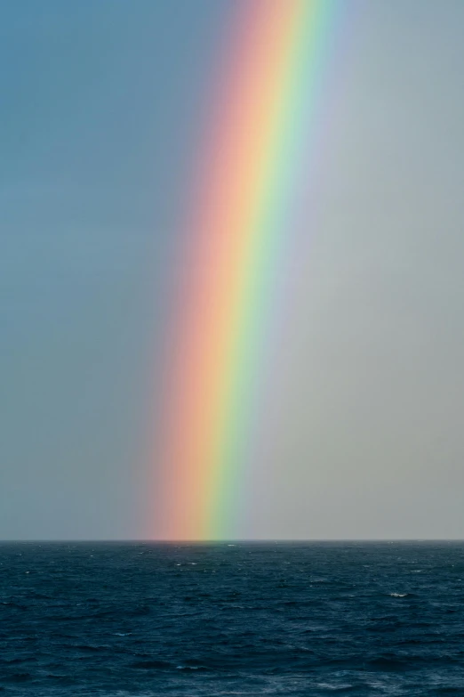 a rainbow in the sky over a body of water, open ocean, paul barson, taken in the late 2010s, ignacio fernandez rios ”