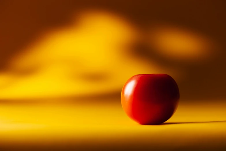 a red apple sitting on top of a table, inspired by Orazio Gentileschi, unsplash, red and yellow light, cherry, smooth background, yellow