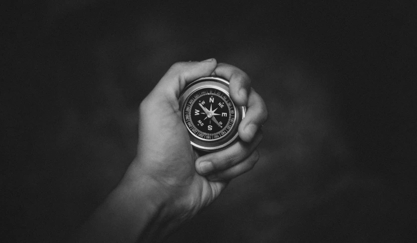 a person holding a compass in their hand, a black and white photo, by Adam Marczyński, visual art, listing image, game, digital image, sweet