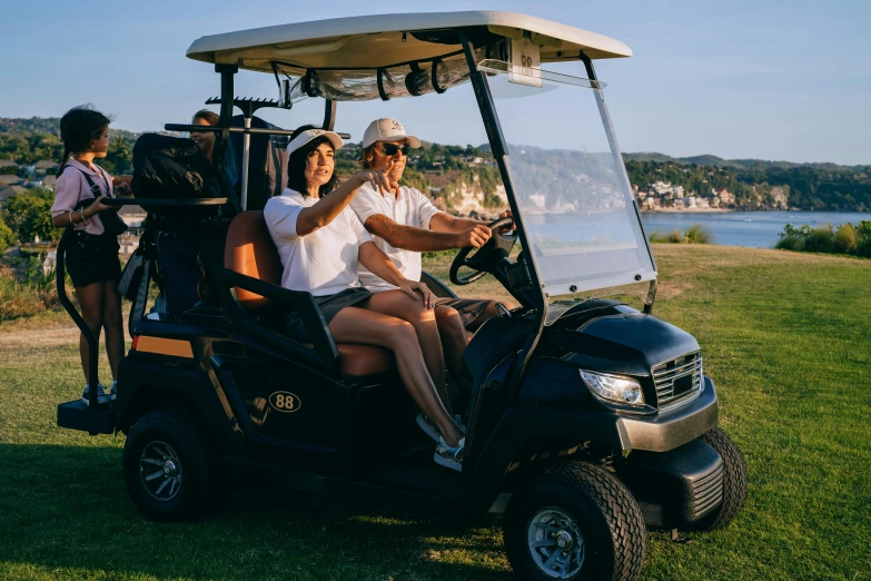 a group of people riding on top of a golf cart, near the sea, tyler edlin and natasha tan, manuka, profile image