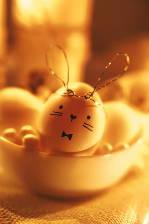 a close up of an egg in a bowl on a table, bunny head, warm glow from the lights, fully decorated, smileeeeeee