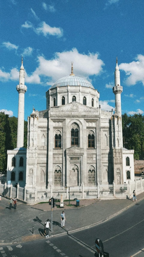 a large white building sitting on the side of a road, inspired by Fikret Muallâ Saygı, hurufiyya, with great domes and arches, front face, grey, paisley