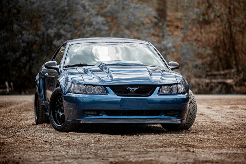 a blue car parked on top of a dirt road, a portrait, mustang, profile image, custom headlights, 2000s photo