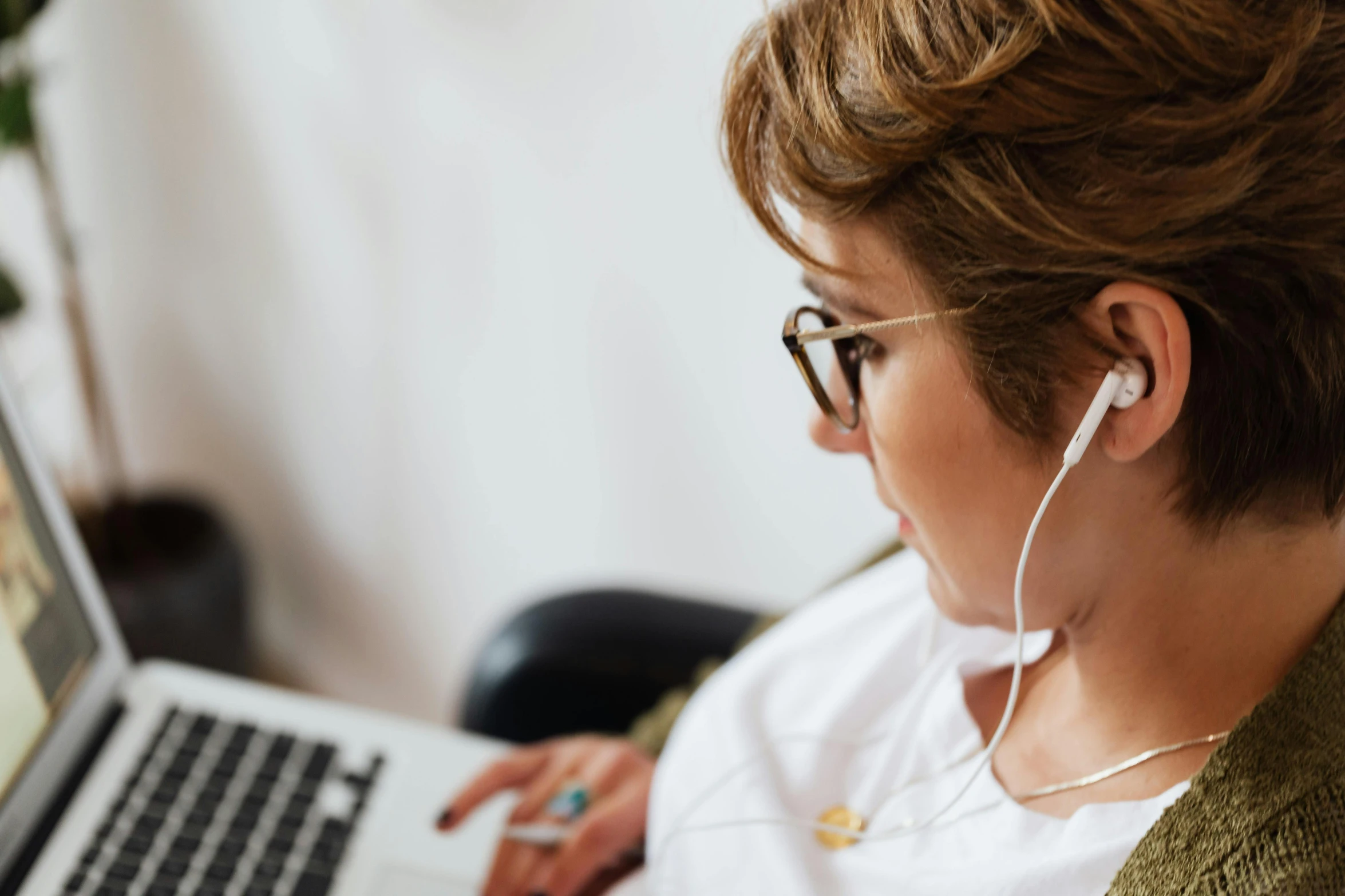 a woman sitting in front of a laptop with headphones on, trending on pexels, wearing a white blouse, avatar image, closeup - view, curvacious