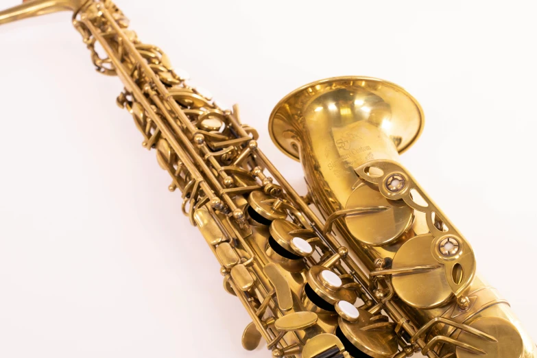 a close up of a saxophone on a white surface, by Brian Thomas, unsplash, art nouveau, super highly detailed, gold and luxury materials, 15081959 21121991 01012000 4k, frontal close up