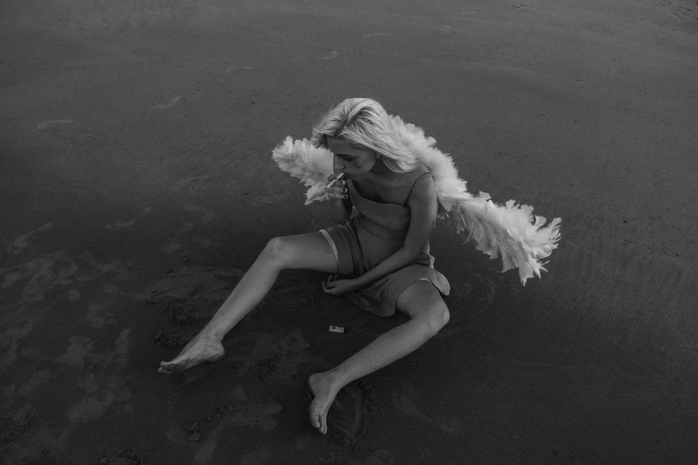 a black and white photo of a woman on the beach, by Andrew Stevovich, conceptual art, biblically acurate angel, feathers ) wet, arca album cover, cupid