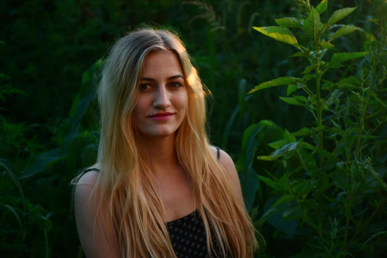 a woman with long blonde hair standing in a field, pexels contest winner, portrait of sanna marin, lush green, low - lighting, portrait image