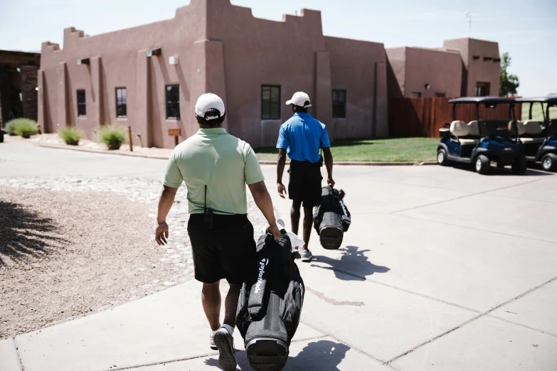 two men walking down a sidewalk carrying golf bags, by Tom Palin, unsplash, happening, new mexico, background image, gunwoo kim and j.dickenson, sports photo