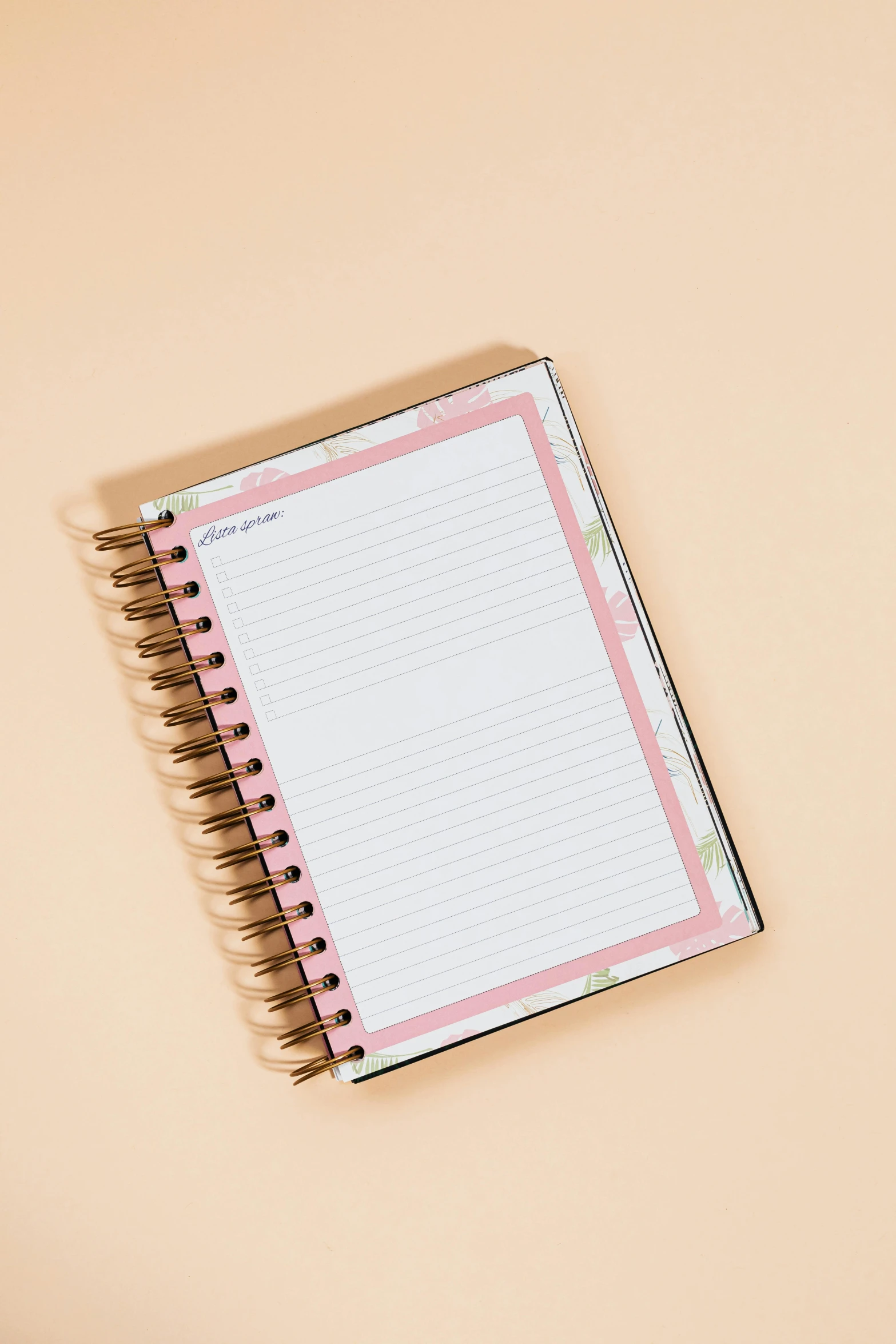 a notepad sitting on top of a desk next to a cup of coffee, light pink background, with ornamental edges, back view also, on a notebook page