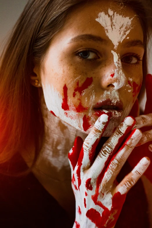 a woman with red and white paint on her face, inspired by Elsa Bleda, trending on pexels, art photography, bloody scene, eating, petite, attractive girl