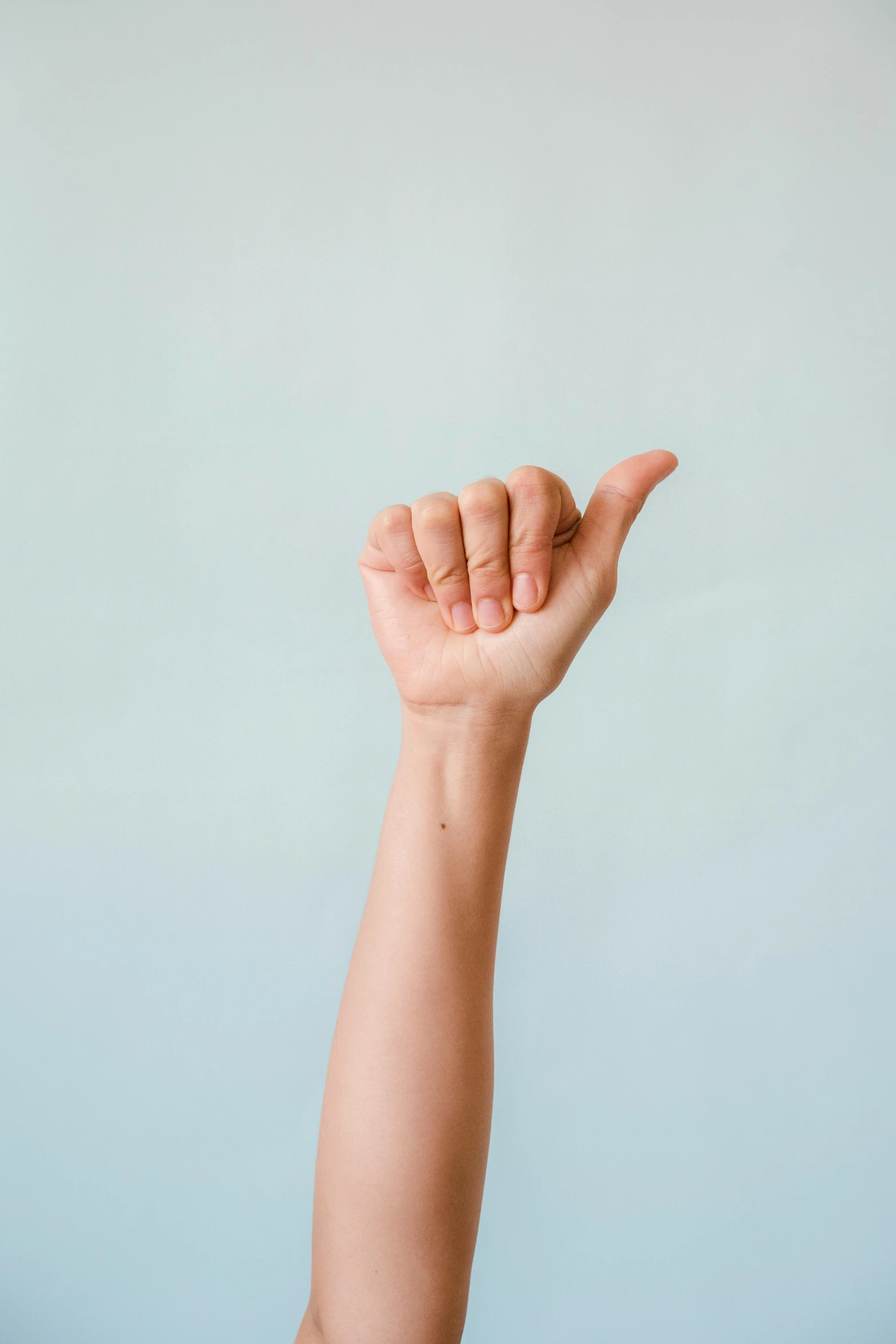 a close up of a person's arm with a frisbee in the air, trending on pexels, aestheticism, doing a thumb up, plain background, stick poke, long chin