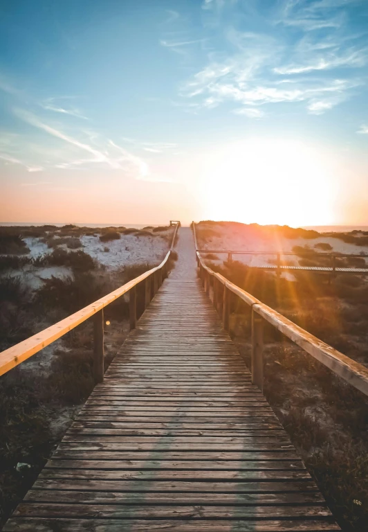 a wooden walkway leading to the beach at sunset, by Niko Henrichon, happening, sunburn, portugal, leading to a beautiful, ( visually stunning