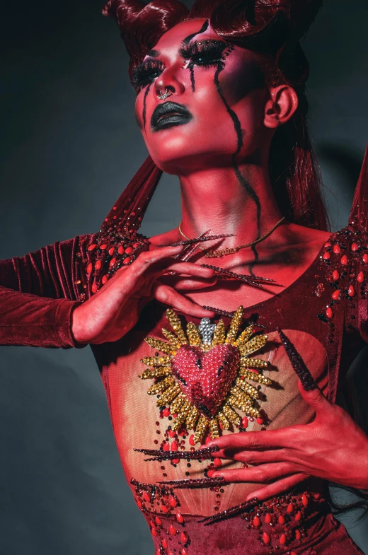 a close up of a person wearing a costume, an album cover, inspired by Hedi Xandt, pexels contest winner, transgressive art, anatomically correct heart, beads cross onbare chest, in red paint, haute couture fashion shoot