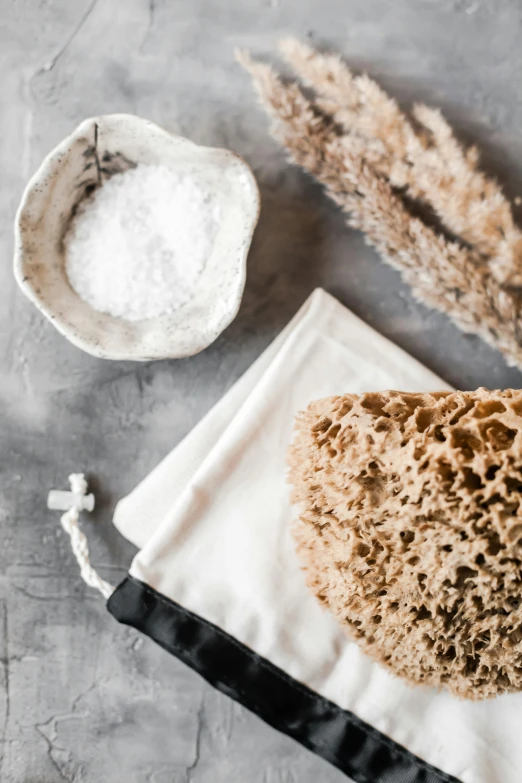 a bag of bread sitting on top of a table, a still life, unsplash, process art, sea sponges, skincare, wash, white salt