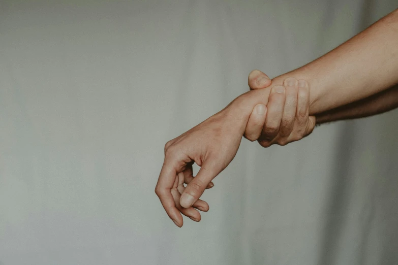 a close up of a person's hand holding something, trending on pexels, spasms, whip in hand, out of body, plain background