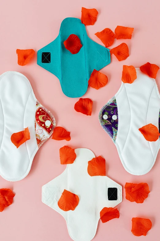 a group of cloth pads sitting on top of a pink surface, by Julia Pishtar, renaissance, rose petals, white and teal garment, kano), three