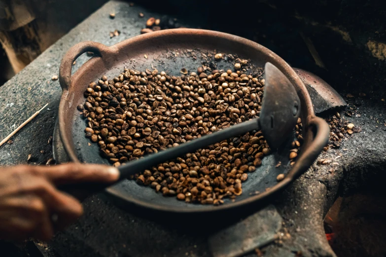 a person scooping coffee beans out of a frying pan, trending on unsplash, renaissance, avatar image, fan favorite, an ancient, chilean