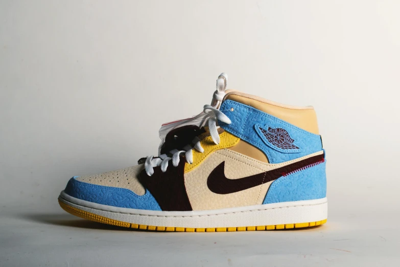 a pair of shoes sitting on top of a white surface, hurufiyya, yellow and blue, “air jordan 1, mid tone, crazy detailed