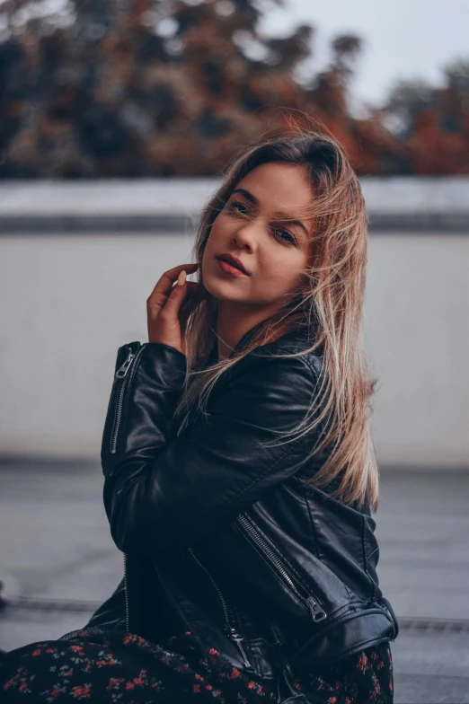 a woman sitting on the ground talking on a cell phone, inspired by Elsa Bleda, pexels contest winner, renaissance, wearing a black leather jacket, headshot profile picture, sydney sweeney, russian girlfriend