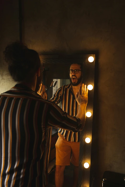 a man that is standing in front of a mirror, inspired by Elsa Bleda, pexels contest winner, wearing stripe shirt, ( ( theatrical ) ), lights off, bearded man