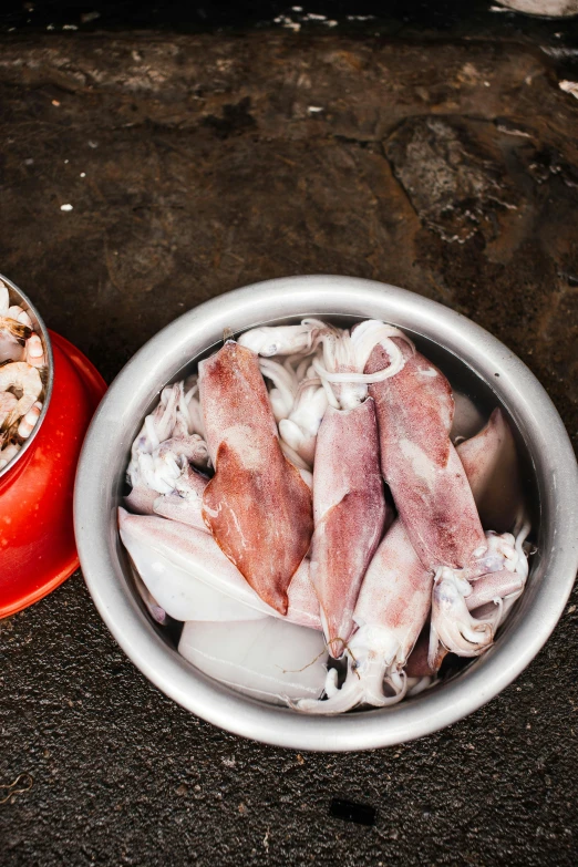 a couple of bowls of food sitting on top of a table, a still life, squid, commercially ready, fresh kill, chicken