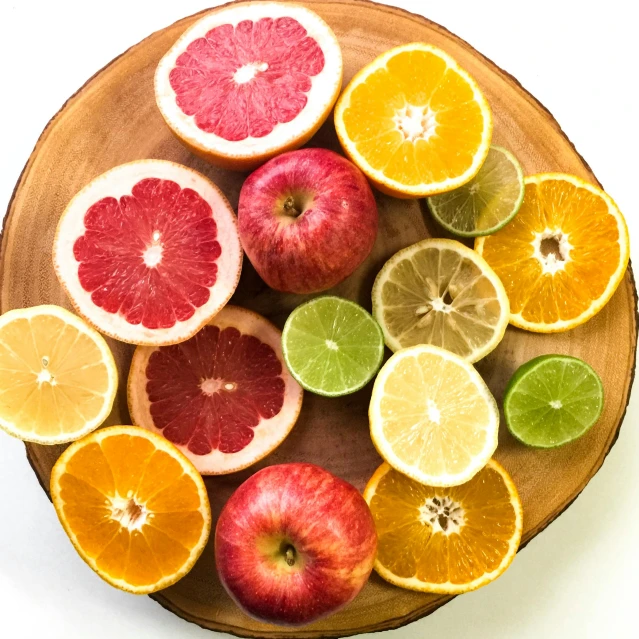 a wooden bowl filled with oranges, apples, and limes, by Carey Morris, pexels, sliced grapefruit, multiple colors, circle, 💋 💄 👠 👗