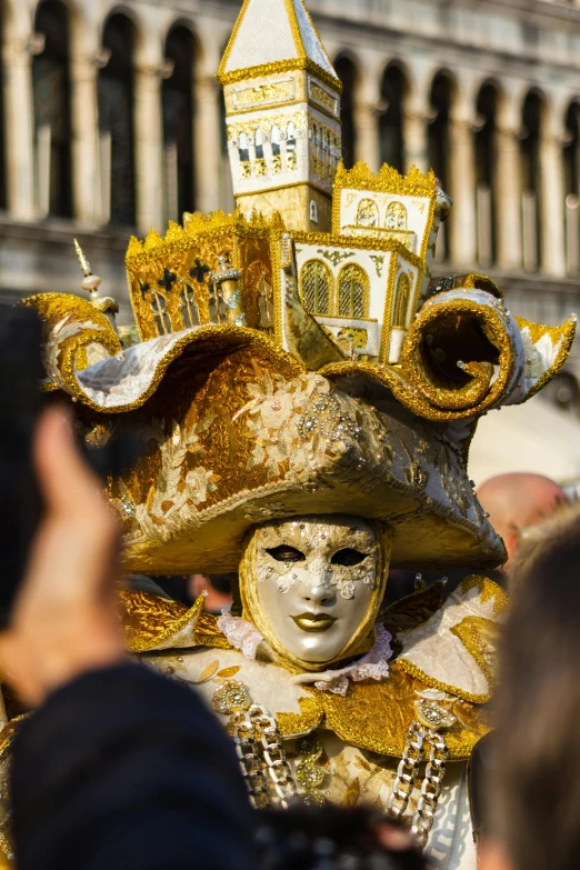 a close up of a person wearing a mask, inspired by Bartolomeo Vivarini, white and gold color scheme, crowded and populated, ornate attire, square