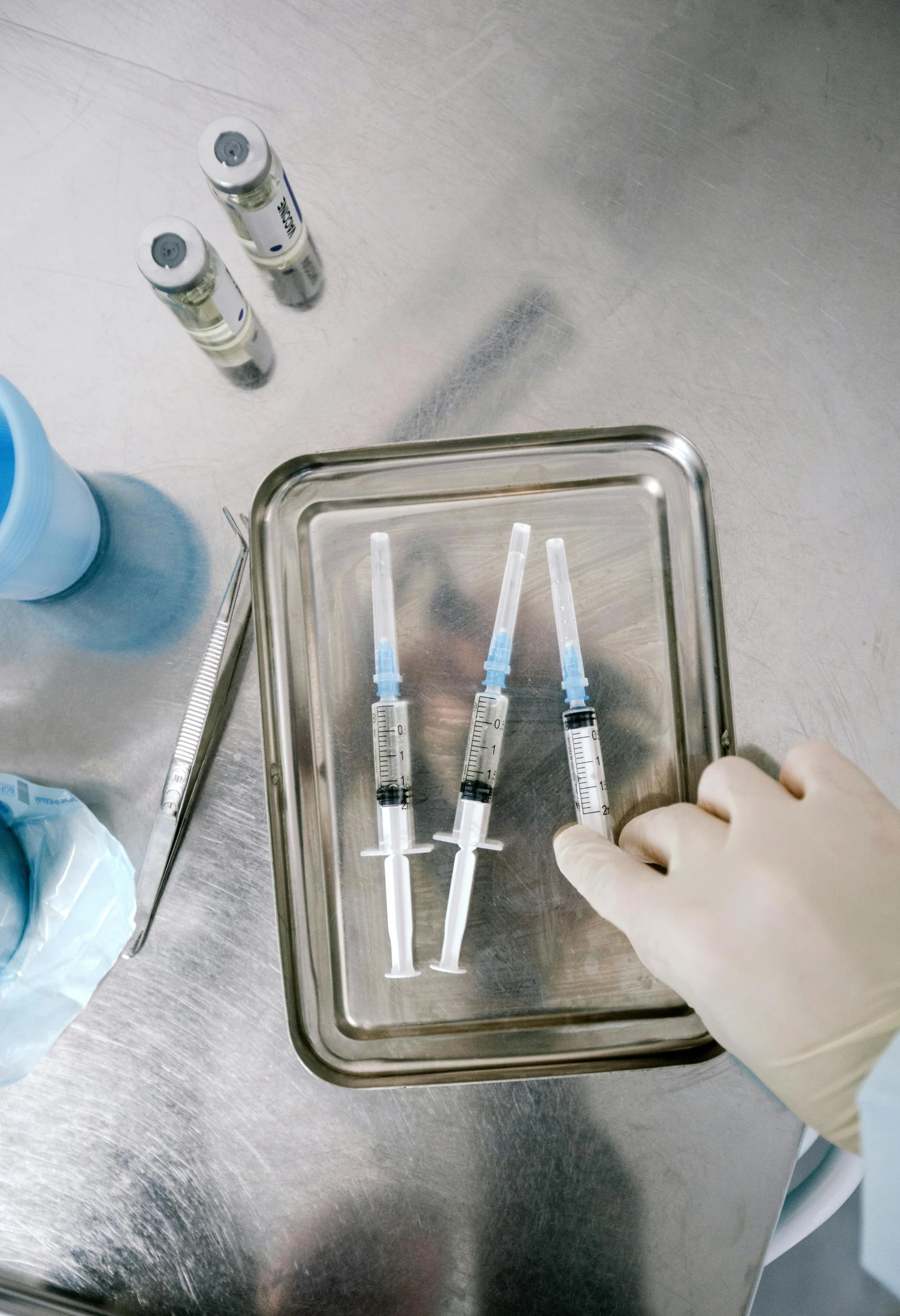 a close up of a person holding a tray with injections, reagents, instagram post, surgical supplies, 3 - piece