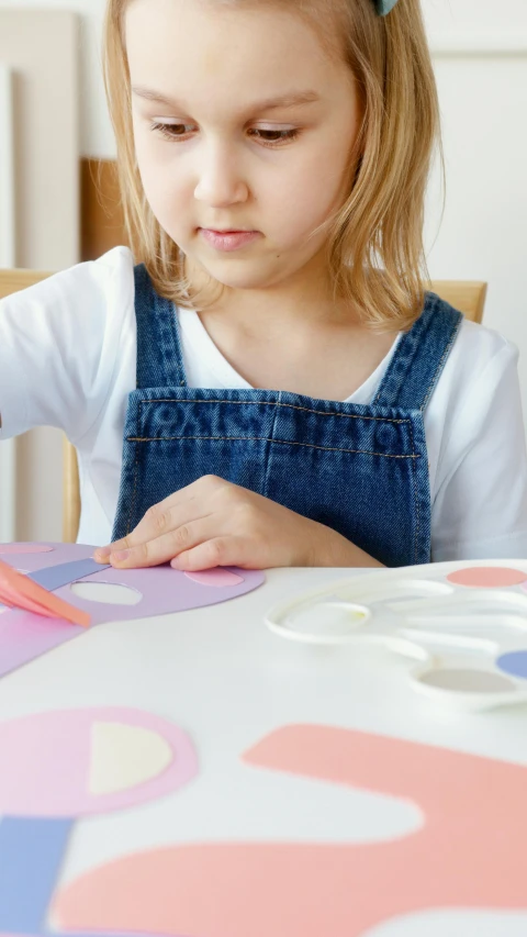 a little girl that is sitting at a table, pexels, process art, large patches of plain colours, thumbnail, diecut, tabletop