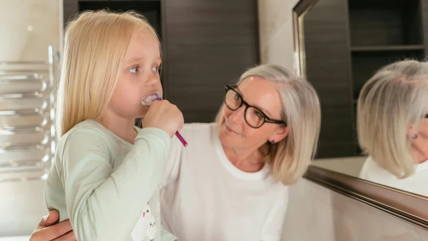 a little girl brushing her teeth in front of a mirror, by Lee Loughridge, pexels contest winner, older woman, manuka, underbite, local conspirologist