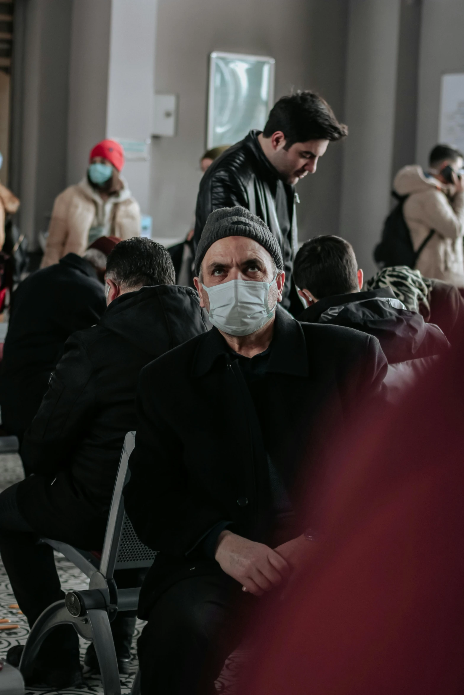 a group of people sitting next to each other, by Adam Marczyński, trending on pexels, hyperrealism, white man with black fabric mask, winter, medical mask, real life photo of a syrian man