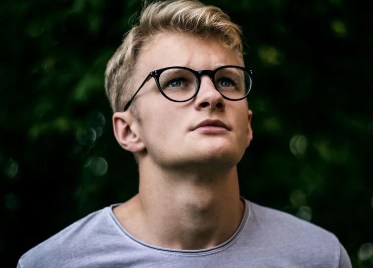 a close up of a person wearing glasses, by Tobias Stimmer, pexels contest winner, blonde guy, proud looking away, young male, avatar image