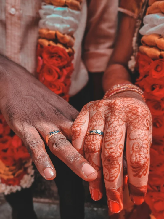 a close up of two people holding hands, an album cover, by Ingrida Kadaka, pexels, symbolism, indian girl with brown skin, celebrating an illegal marriage, orange and teal color, 15081959 21121991 01012000 4k