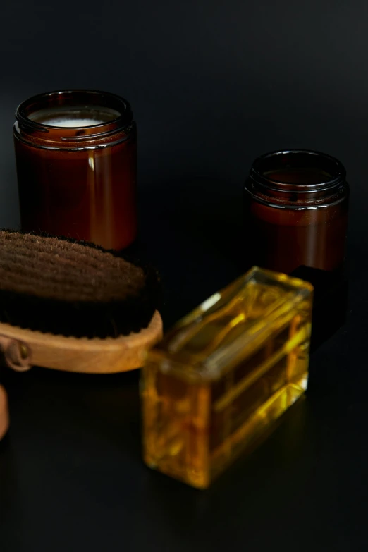 a close up of a person holding a brush, lots of jars and boxes of herbs, liquid translucent amber, hair gel combed backwards, thumbnail