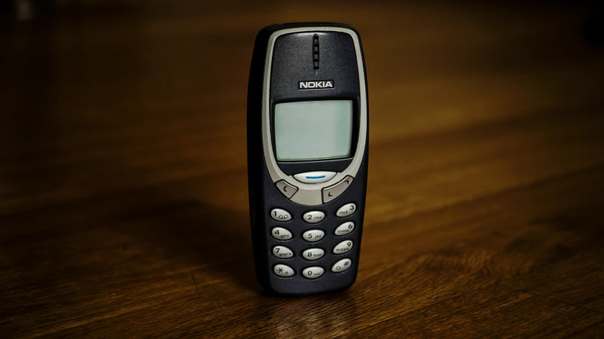 a cell phone sitting on top of a wooden table, by Matthias Stom, unsplash, hyperrealism, taken in the early 1990s, avatar image, vehicle, aged 2 5