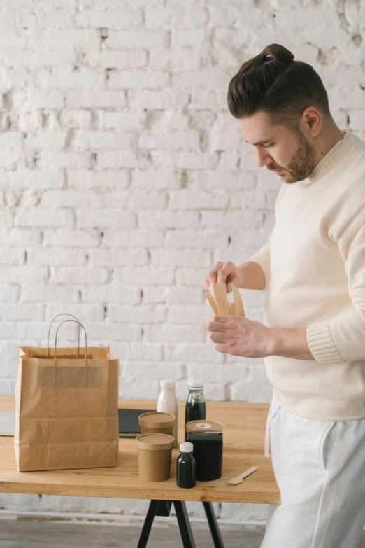 a man that is standing in front of a table, trending on pexels, packaging, carefully crafted, recipe, bandages