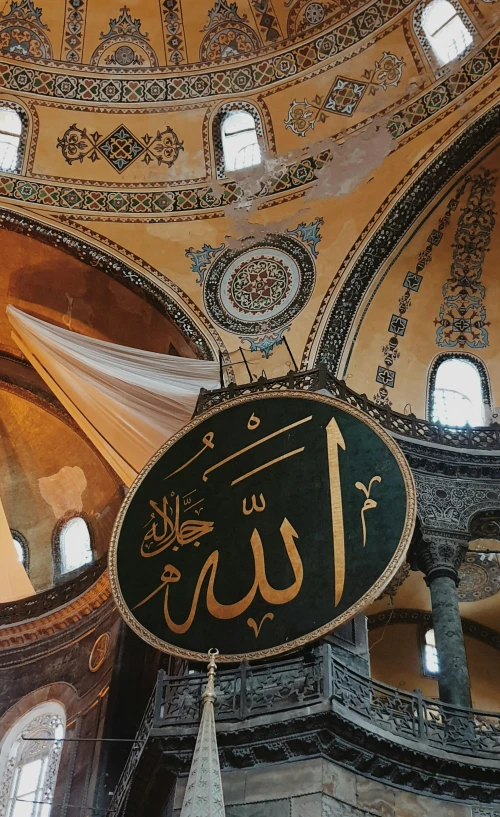 a clock hanging from the ceiling of a building, an album cover, by Jessie Algie, trending on unsplash, arabesque, mosque interior, 256x256, calligraphy, istanbul