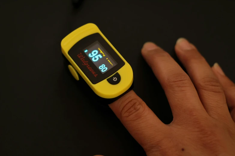 a close up of a person's hand holding a cell phone, vitals visualiser!!, yellow, taken with sony alpha 9, medical supplies