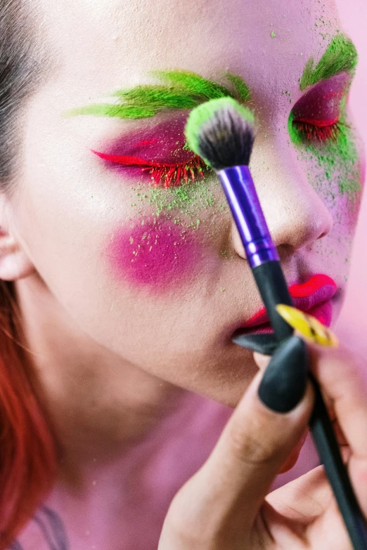 a close up of a person with a makeup brush, inspired by Taro Yamamoto, trending on pexels, pop art, green and pink, putting makeup on, organic seductive geisha, multi - coloured